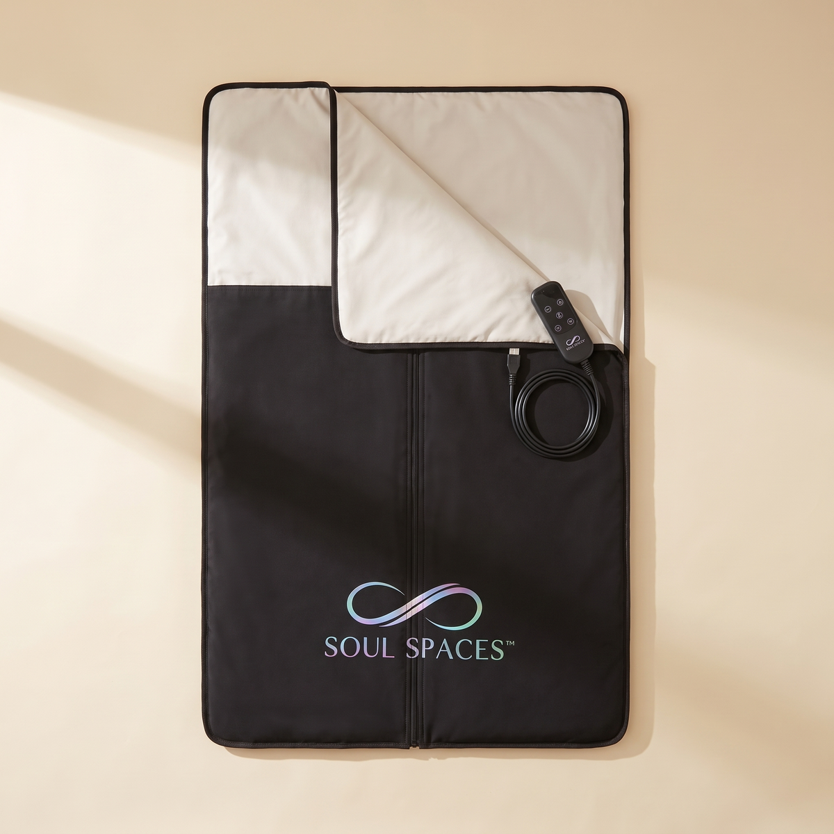 The Sanctuary Sauna Blanket laid smooth on a cream background, top folded open with controller